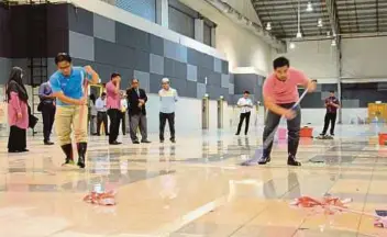  ?? [FOTO MUHAMMAD ZUHAIRI ZUBER /BH] ?? Pekerja melakukan proses pembersiha­n di lokasi penganjura­n makanan berasaskan daging babi sempena Festival Tastefully Food and Beverage Expo, pagi semalam.