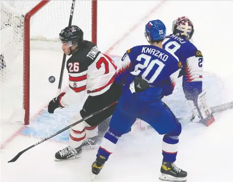  ?? GREG SOUTHAM ?? Canada's Philip Tomasino scores on Slovakia's goalie Samuel Hlavaj as Samuel Knazko watches during the third period Sunday in Edmonton. Canada has beaten Slovakia in their past 14 world junior encounters.