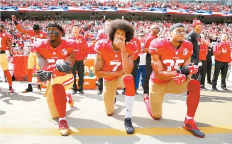  ?? EPA-Yonhap ?? San Francisco 49ers back-up quarterbac­k Colin Kaepernick, center, teammate Eli Harold, left, and free safety Eric Reid, right, take a knee during the US national anthem before the NFL game against the Dallas Cowboys at Levi’s Stadium in Santa Clara,...