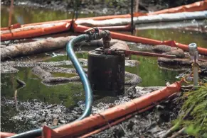  ??  ?? The state works to contain and plug a crude oil spill at Veto Lake, likely from an old orphaned well in Washington County.