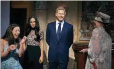  ?? ANDRES KUDACKI - THE ASSOCIATED PRESS ?? People take pictures of wax sculptures of Meghan Markle, second left, and Prince Harry, second right, during a viewing party of the royal wedding of Meghan Markle and Prince Harry of Wales, at the Madame Tussauds wax museum on Saturday, in New York.