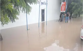  ?? ?? Acceso a un local comercial está totalmente inundado por agua de lluvia.