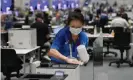  ?? Photograph: Zsolt Czeglédi/EPA ?? A Tokyo 2020 employee disinfects a workstatio­n at the main press centre.