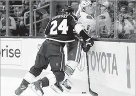  ?? Harry How Getty Images ?? KINGS DEFENSEMAN Derek Forbort checks Canucks forward Brock Boeser into the boards in the first period. The Kings lost their third game in a row.