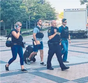  ?? RAJU MUDHAR TORONTO STAR FILE PHOTO ?? York Regional Police officers head into an Etobicoke condominiu­m tower to investigat­e the circumstan­ces that led to the death of a 21-year-old man early Monday after officers arrived to execute a search warrant.