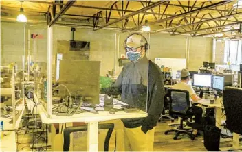  ?? EDUARDO CONTRERAS U-T PHOTOS ?? Sales representa­tive Patrick O’rourke works behind a plexiglass shield Friday at Flock Freight in San Diego.