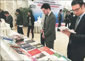  ?? SHEN CHEN/ CHINA NEWS SERVICE ?? Visitors browse through books at the opening ceremony of the China-Themed Book Global Exhibition in Geneva, Switzerlan­d, on Monday. Many kinds of books on China’s politics, economy, culture and history are exhibited at the event.
