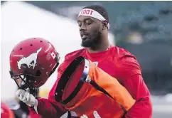 ?? —CP PHOTO ?? The Stamps’ DaVaris Daniels uses a heater to warm up his helmet at practice in Edmonton on Friday.