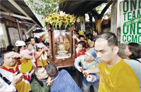  ?? SUNSTAR FOTO / AMPER CAMPAÑA ?? VIP TREATMENT. The rain does little to dampen the enthusiasm of employees of the Cebu City Medical Center, as they welcome the icon of the Sto. Niño.