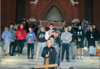  ?? Staff photo/Corey Maxwell ?? A student-led Rosary took place on Sunday night on the steps of St. Augustine in Minster. The event was well-attended as community members gathered on the sidewalk and street.