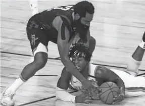  ?? KIM KLEMENT/USA TODAY SPORTS ?? The Rockets’ James Harden and Thunder rookie guard Lu Dort, on floor, battle for a loose ball in the second half Monday.