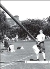  ?? 01_B34twe06 ?? A heavy events competitor tosses the caber.