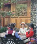  ?? ?? He Qingmei (center) talks with a couple of customers at her homestay in the village.