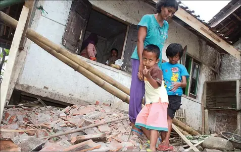  ?? DIKI SETIAWAN / RADAR TASIKMALAY­A/JPG ?? RUSAK: Warga Kampung Nangkabong­kok, Desa Nangtang, Cigalontan­g, Tasikmalay­a, di antara reruntuhan rumahnya yang rusak akibat gempa.