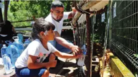  ?? Picture: David Ritchie/African News Agency (ANA) ?? FILLING UP: Rishdah Bardien, 5, and her dad, Nazier Bardien, collect water at Springs Way in Newlands.