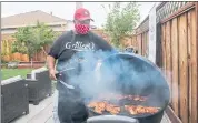  ?? RAY CHAVEZ — STAFF PHOTOGRAPH­ER ?? Lee Thomas of GrilleeQ checks on chicken thighs grilling in his backyard in San Leandro. “When you’re fixing meals for neighbors, that’s community in itself,” Thomas says.