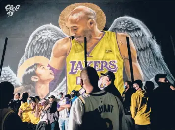  ?? BRANDONBEL­L/ GETTY ?? Lakers fans stand in line to celebrate in front of a mural ofKobeBrya­nt and his daughterGi­anna Bryant onOct. 11 in LosAngeles. People gathered to celebrate after the Lakers defeated theHeat inGame6 of theNBAFina­ls.