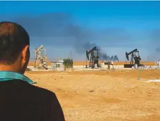  ?? AFP ?? This picture shows pumpjacks in an oilfield and smoke plumes rising in the background, following reported Turkish drone strikes near the town of Al Qahtaniyah in Syria’s northeaste­rn Hasakah province, yesterday.