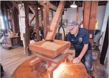  ?? BOB TYMCZYSZYN THE ST. CATHARINES STANDARD ?? Bruce Merritt watches over grain going into a mill stone as volunteers were busy milling flour at the Morningsta­r Grist Mill by Decew Falls.