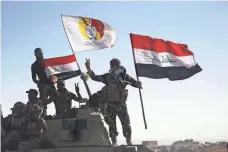  ?? MOHAMMED SAWAF, AFP/GETTY IMAGES ?? Iraqi forces supported by fighters from the Abbas Brigade flash the sign for victory as they advance toward the city of Tal Afar.