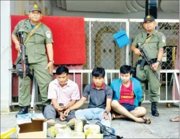  ?? SUPPLIED ?? Officials pose for a photograph with three suspects arrested in a drug bust on Saturday in Phnom Penh.