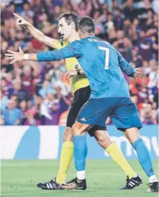  ??  ?? ► Cristiano se apresta a empujar al árbitro .