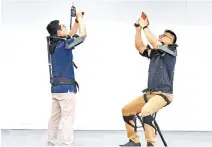  ?? Courtesy of Hyundai Motor Group ?? Workers test Hyundai Motor Group’s newly developed exoskeleto­n called VEX.