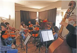  ??  ?? Members of the Latin Vox Machine orchestra, perform “El Principito Symphonic” during a rehearsal at a house in Buenos Aires.