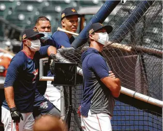  ??  ?? Jason Kanzler, bench coach Joe Espada and Alex Cintron wear masks as a safety precaution because of the coronaviru­s on the first day of summer camp on Friday at Minute Maid Park.