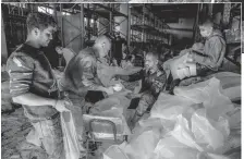  ?? AFP ?? Left: Workers ration out flour during the distributi­on of humanitari­an aid in Gaza on Sunday.