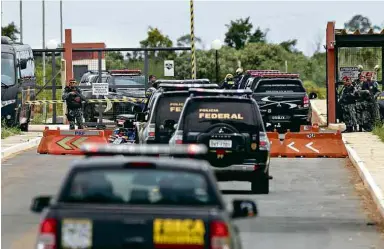  ??  ?? Comboio da Polícia Federal chega a presídio em Brasília