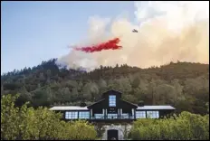  ?? ASSOCIATED PRESS ?? An air tanker drops retardant Sunday on the Glass Fire burning above Davis Estates winery in Calistoga, Calif.