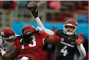  ?? Arkansas Democrat-Gazette/THOMAS METTHE ?? Arkansas quarterbac­k Ty Storey (4) passes over defensive lineman Deion Malone during Saturday’s Red-White game at War Memorial Stadium in Little Rock. Storey and teammate Cole Kelley each passed for 126 yards and one touchdown.