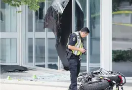  ?? DARRYL DYCK / THE CANADIAN PRESS ?? A police officer examines a motorcycle after stunt driver Joi “SJ” Harris died working on the movie Deadpool 2 in a crash on a set near Canada Place on Monday.