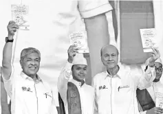  ?? - Bernama photo ?? Deputy Prime Minister Datuk Seri Dr Ahmad Zahid Hamidi (left) holding up the book on Occupation­al Safety and Health (KKP) guide book for (Maahad) Tahfiz schools 2018 after opening the national level KKP Management Seminar. Also present is National...