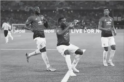  ??  ?? Manchester United midfielder Paul Pogba (center) celebrates with Romelu Lukaku (left) and Anthony Martial after scoring their first goal in the Champions League Group H match against Young Boys on Wednesday in Bern, Switzerlan­d.