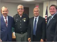  ?? CHAD FELTON — THE NEWS-HERALD ?? Lake County Commission­er Ron Young stands with Lake County Chief Deputy Sheriff Frank Leonbruno, second from left, and fellow Commission­ers Jerry Cirino and John Hamercheck in chambers on Aug. 20. Following the recent retirement announceme­nt of Sheriff Dan Dunlap, the board unanimousl­y adopted a resolution during the regular session to appoint Leonbruno acting sheriff effective Sept. 1.