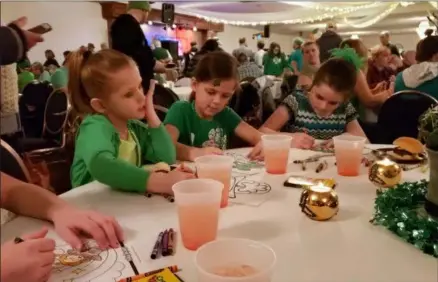  ?? ZACHARY SRNIS — THE MORNING JOURNAL ?? Cousins Kindle Fellows, 5, left, of Cleveland, Addison Hanratty, 7, of Avon Lake, and Karlee Kenuth, 7, of Avon, participat­e in a coloring contest at Sober Seventeent­h at Ahern’s Banquet Center at 726 Avon Belden Road in Avon Lake.