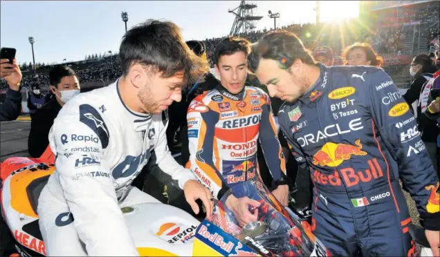  ?? ?? Pierre Gasly, Marc Márquez y Sergio Pérez observan la Honda del equipo Repsol durante el reciente ‘Honda Thanks Day’ organizado en el circuito de Motegi (Japón).