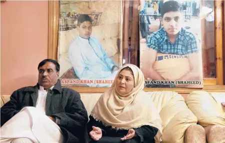  ?? MUHAMMAD SAJJAD/AP 2021 ?? Shahana Khan, right, and Ajoon Khan with photos of their son, Asfand, who was killed in a 2014 assault by Pakistani Taliban militants.