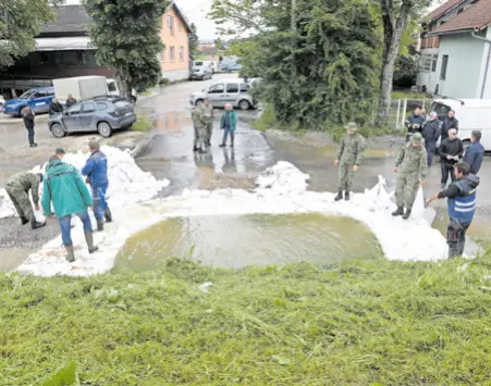  ?? ?? PETRINJA: Kupa se probila kroz kanalizaci­jski sustav u Ulici Antuna Mihanovića, kamo je poslana vojska. Ojačavali su se i nasipi na dijelu gdje je u tijeku obnova nasipa oštećenih u potresu