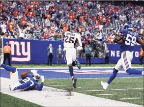  ?? Adam Hunger / Associated Press ?? Broncos running back Melvin Gordon runs past the Giants' Adoree’ Jackson (22) and Lorenzo Carter for a touchdown during the second half on Sunday in East Rutherford, N.J. The Broncos won 27-13.