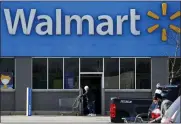  ?? ASSOCIATED PRESS FILE PHOTO ?? A woman pushes a shopping cart to enter a Walmart in Rolling Meadows, Ill.