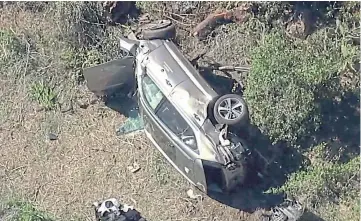  ??  ?? WRECKED: Woods’ car lies badly damaged by the roadside in Los Angeles.