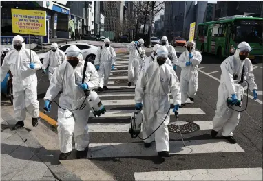  ??  ?? South Korean soldiers spray antiseptic solution against the coronaviru­s in Gangnam district in Seoul