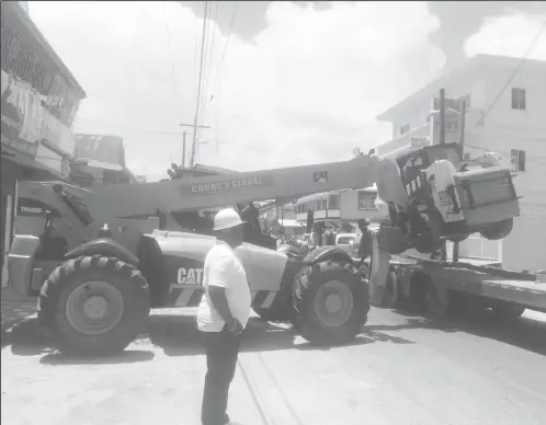  ??  ?? City Building Inspector Marlon Harris looks on as the loader is removed