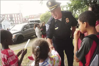  ?? File photo by Ernest A. Brown ?? Woonsocket Police Chief Thomas Oates greets youngsters in River Island Park during a past year’s National Night Out event. The Woonsocket Police Department recently earned re-acreditati­on status from an assessment panel that studied all of the department’s policies and operations.