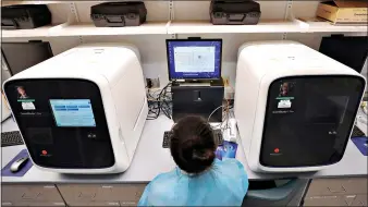  ??  ?? Dany Fu, a biomedical engineerin­g graduate student, works on a testing work station in COVID-19 on-campus lab July 23 at Boston University in Boston. (AP Photo/Charles Krupa) the new