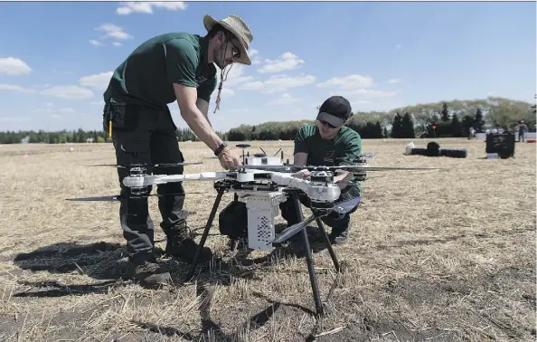  ?? GREG SOUTHAM ?? Drone pilots Jeremie Leonard, left, and Spencer Walker-Fooks from BioCarbon Engineerin­g will be helping the Canadian Forest Service with the first Canadian instance of using drones to plant tree seeds at a five-hectare clear-cut site about 40 km south...