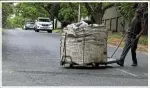  ?? ?? A waste picker walks along a Parkhurst street. Residents of the affluent suburb say crime has soared since waste pickers and homeless people began living on their doorstep.